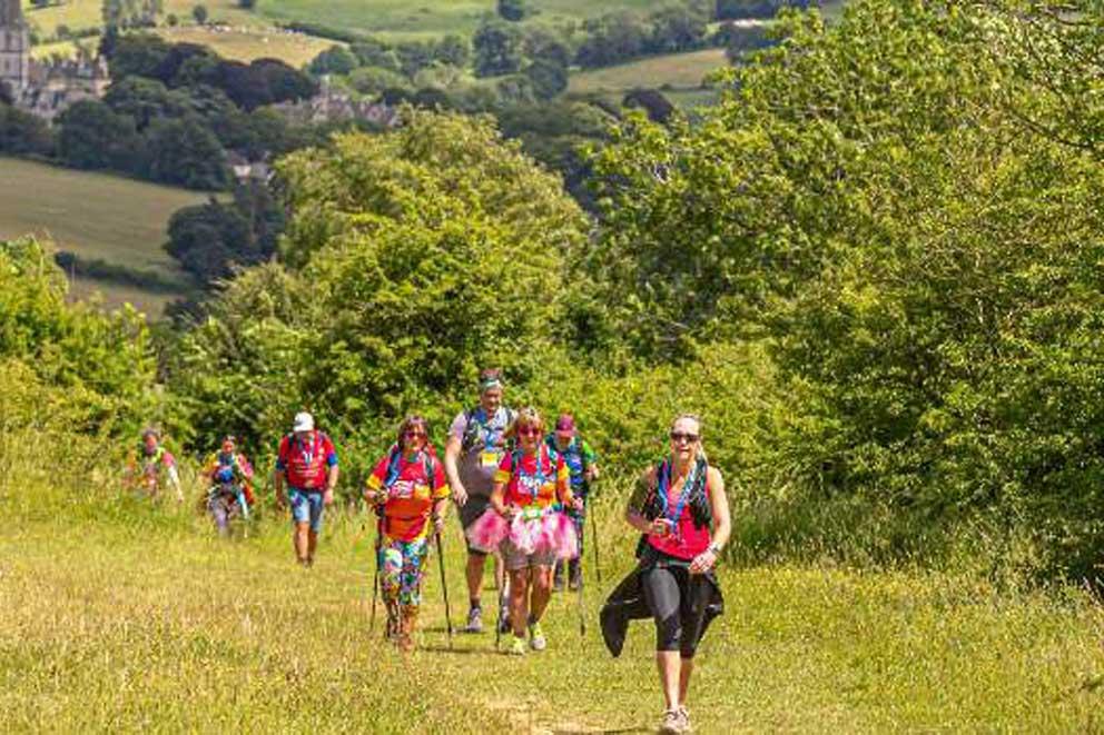 A group of walkers walking uphill in the countryside.