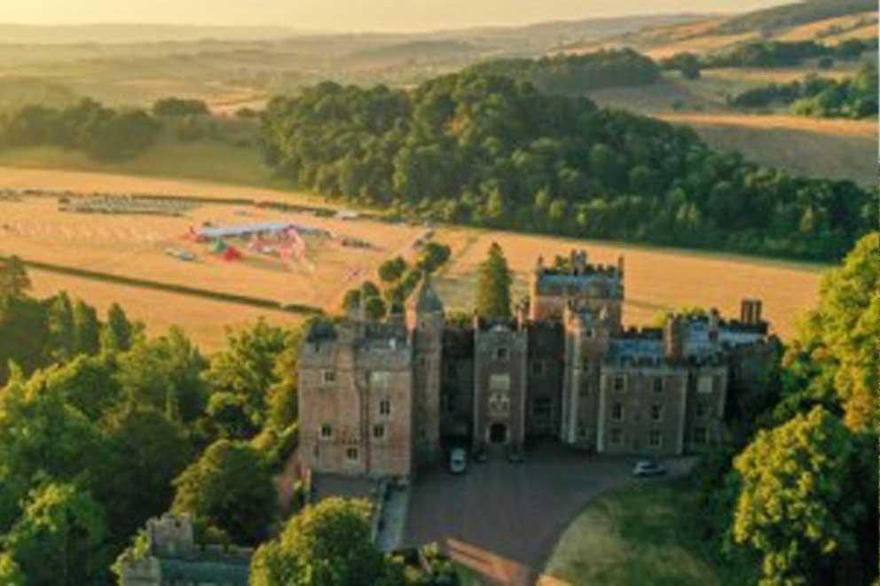 An aerial view of Dunster Castle and the South West Coast 50 Challenge basecamp behind.